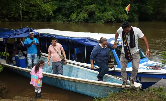 Jani Silva, 63, gets off a boat, on the outskirts of Puerto Asis, Colombia, Wednesday, Nov. 26, 2025. (AP Photo/Ivan Valencia)