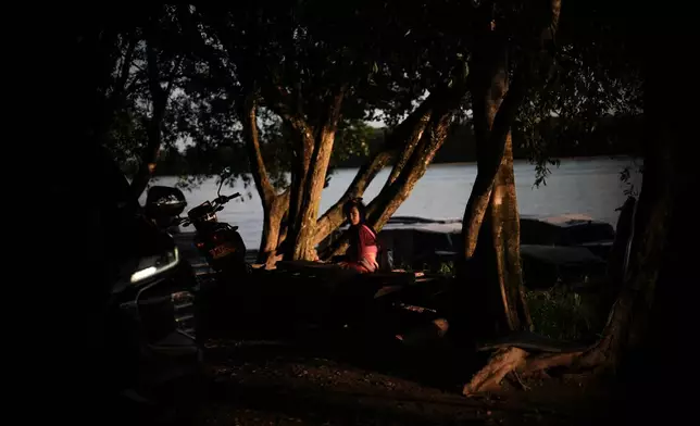 A girl waits at the port in Puerto Asis, Colombia, Wednesday, Nov. 26, 2025. (AP Photo/Ivan Valencia)