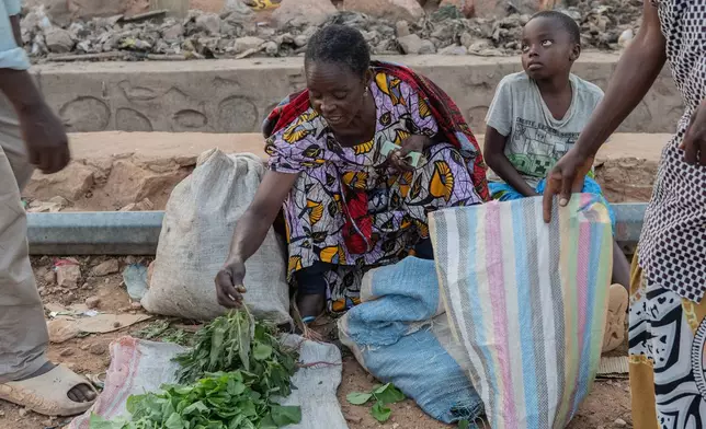 People buy and sell as residents return to their homes in Uvira, Democratic Republic of Congo, Saturday, Dec. 13, 2025. (AP Photo/Moses Sawasawa)