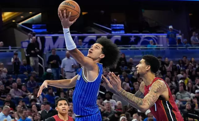 Orlando Magic guard Anthony Black shoots as he gets past Miami Heat center Kel'El Ware, right, during the second half of an NBA basketball game, Friday, Dec. 5, 2025, in Orlando, Fla. (AP Photo/John Raoux)