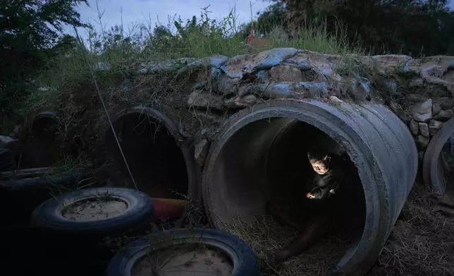 A Thai resident who fled clashes between Thai and Cambodian soldiers, uses mobile phone while taking shelter in Buriram province, Thailand, Tuesday, Dec. 9, 2025. (AP Photo/Wason Wanichakorn)