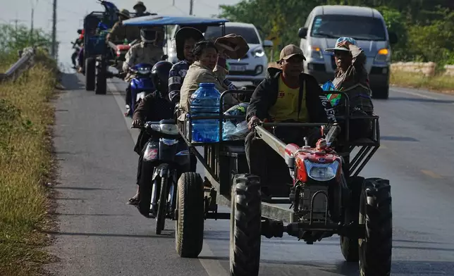 Local people transported by tractors and motorcycles flee from their home in northwestern provinces of Cambodia's border with Thailand, Tuesday, Dec. 9, 2025. (AP Photo/Heng Sinith)