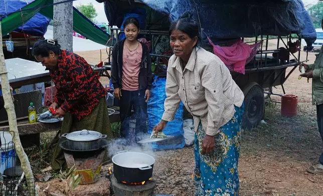 People cook breakfast as they take refuge in Srey Snam, Siem Reap province, Cambodia Wednesday, Dec. 10, 2025, after fleeing from home following a fighting between Cambodia and Thailand over territorial claims. (AP Photo/Heng Sinith)