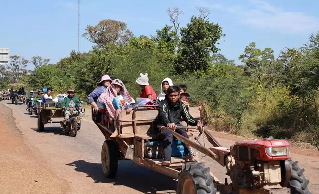 In this photo released by Agence Kampuchea Press (AKP), Cambodian villagers sit on tractors as they flee from the home in Preah Vihear province, Cambodia, Monday, Dec. 8, 2025. (AKP via AP)