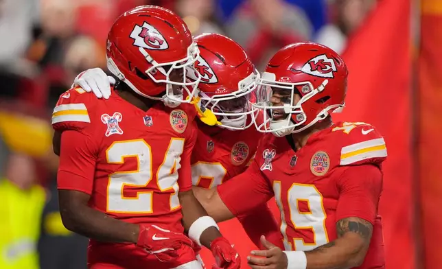 Kansas City Chiefs running back Brashard Smith (24) celebrates with wide receiver Juju Smith-Schuster, center, and quarterback Chris Oladokun (19) after scoring a touchdown during the first half of an NFL football game against the Denver Broncos Thursday, Dec. 25, 2025, in Kansas City, Mo. (AP Photo/Charlie Riedel)