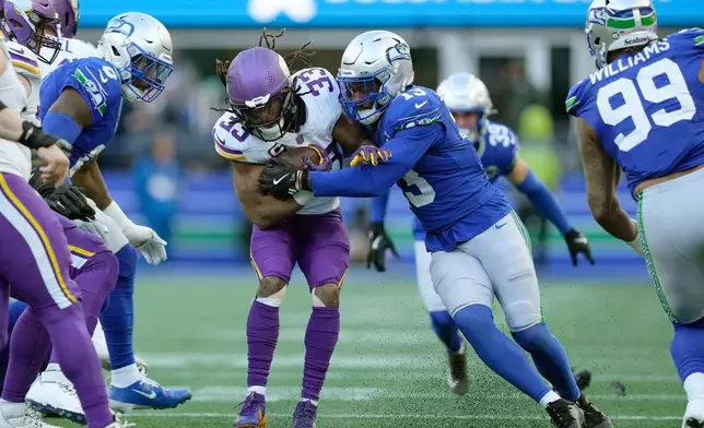 Seattle Seahawks linebacker Ernest Jones IV (13) tackles Minnesota Vikings running back Aaron Jones Sr. (33) during the second half of an NFL football game, Sunday, Nov. 30, 2025, in Seattle. (AP Photo/Stephen Brashear)