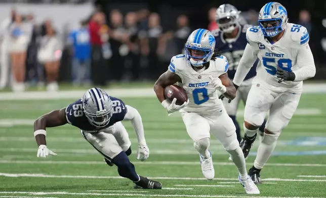 Detroit Lions running back Jahmyr Gibbs (0) runs the ball as Dallas Cowboys linebacker Jr. Kenneth Murray (59) tries to stop him during the first half of an NFL football game Thursday, Dec. 4, 2025, in Detroit. (AP Photo/Paul Sancya)