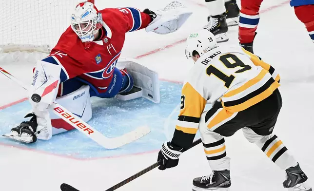Montreal Canadiens goaltender Jacob Fowler (32) makes a save against Pittsburgh Penguins' Connor Dewar (19) during the second period of an NHL hockey game, in Montreal, Saturday, Dec. 20, 2025. (Graham Hughes/The Canadian Press via AP)