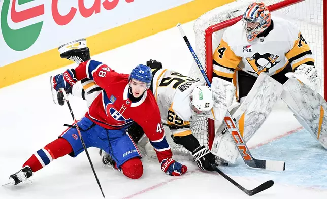 Pittsburgh Penguins goaltender Stuart Skinner, right, looks on as Montreal Canadiens' Lane Hutson (48) and Penguins' Erik Karlsson (65) collide in front of his net during the first period of an NHL hockey game in Montreal, Saturday, Dec. 20, 2025. (Graham Hughes/The Canadian Press via AP)