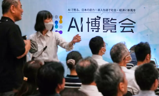 FILE - An usher directs an attendee to a seat for a seminar at a convention titled AI Expo in Tokyo, on Aug. 27, 2025. (AP Photo/Hiro Komae, File)