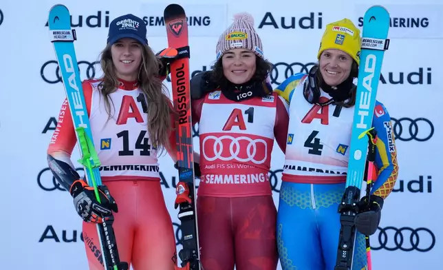 Austria's Julia Scheib, center, winner of an alpine ski, women's World Cup giant slalom, poses with second-placed Switzerland's Camille Rast, left, and third-placed Sweden's Sara Hector, in Semmering, Austria, Saturday, Dec. 27, 2025. (AP Photo/Giovanni Auletta)