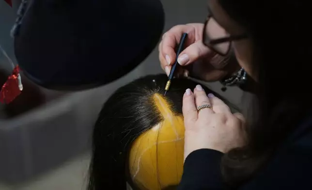 A wig receives final touches ahead of the dress rehearsal of Dmitri Shostakovich's Lady Macbeth of the Mtsensk District at La Scala Opera House in Milan, Italy, Thursday, Dec. 4, 2025. (AP Photo/Antonio Calanni)