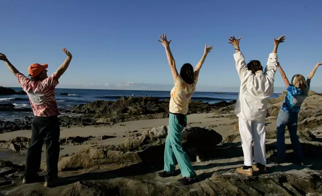 FILE - Class members participate in a laughter yoga class on Main Beach in Laguna Beach, Calif., Nov. 29, 2006. (AP Photo/Chris Carlson, File)
