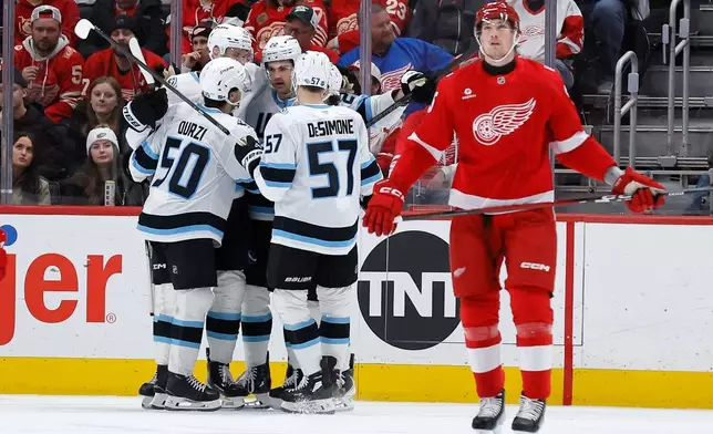 Utah Mammoth center Jack McBainm (22), third from left, celebrates with defenseman Sean Durzi (50), center Alexander Kerfoot (15) and defenseman Nick Desimone (57) after scoring against the Detroit Red Wings during the second period of an NHL hockey game Wednesday, Dec. 17, 2025, in Detroit. (AP Photo/Duane Burleson)