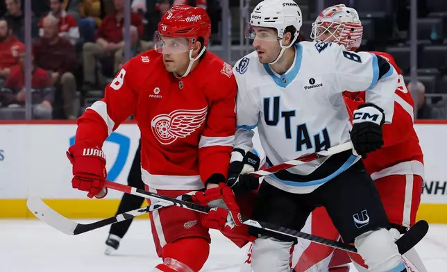 Detroit Red Wings defenseman Ben Chiarot, left, and Utah Mammoth center Nick Schmaltz (8) tangles their sticks during the first period of an NHL hockey game Wednesday, Dec. 17, 2025, in Detroit. (AP Photo/Duane Burleson)