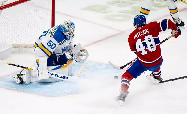Montreal Canadiens' Lane Hutson (48) scores on St. Louis Blues goaltender Jordan Binnington (50) during the first period of an NHL hockey hgame, in Montreal, Sunday, Dec. 7, 2025. (Christopher Katsarov/The Canadian Press via AP)