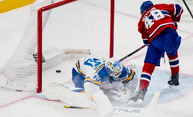 Montreal Canadiens' Lane Hutson (48) scores on St. Louis Blues goaltender Jordan Binnington (50) during the first period of an NHL hockey game, in Montreal, Sunday, Dec. 7, 2025. (Christopher Katsarov/The Canadian Press via AP)