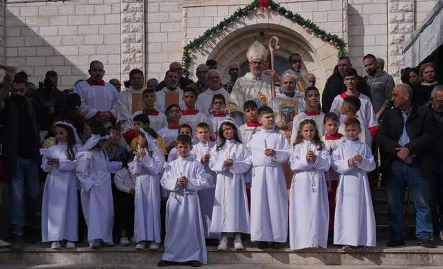 Cardinal Pierbattista Pizzaballa, the Latin Patriarch of Jerusalem, poses for the photos with Palestinian parishioners after leading a mass ahead of Christmas celebrations at the Holy Family Catholic Church in Gaza City, Sunday, Dec. 21, 2025. (AP Photo/Jehad Alshrafi)