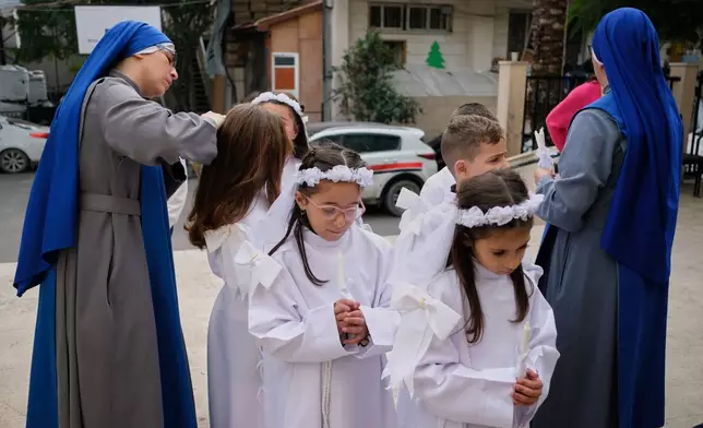 Children and nuns gather outside the Holy Family Catholic Church before attending a mass ahead of Christmas celebrations in Gaza City, Sunday, Dec. 21, 2025. (AP Photo/Jehad Alshrafi)