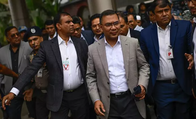 Bangladesh Nationalist Party (BNP) Acting Chairman, Tarique Rahman, center, arrives at Hazrat Shahjalal International Airport in Dhaka, Thursday, Dec. 25, 2025, after returning from London, ending more than 17 years of self-imposed exile. (AP Photo/Mahmud Hossain Opu)