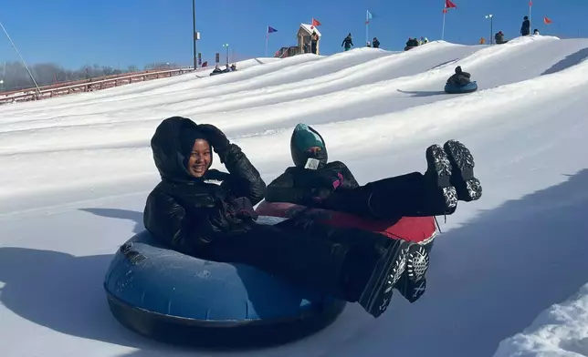 FILE - Nawal Hirsi, right, part of the Twin Cities' Somali community, goes snow tubing with her family as part of a group promoting outdoors activities by Muslim women, at Elm Creek Park Reserve in Maple Grove, Minn., on Jan. 4, 2025. (AP Photo/Giovanna Dell'Orto, File)