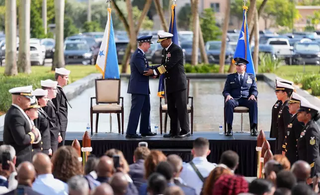 Navy Adm. Alvin Holsey, center, shakes hands with Gen. Dan Caine, chairman of the Joint Chiefs of Staff, during a relinquishment of command and retirement ceremony, handing over command to Air Force Lt. Gen. Evan Pettus, right, at U.S. Southern Command (SOUTHCOM), Friday, Dec. 12, 2025, in Doral, Fla. (AP Photo/Rebecca Blackwell)