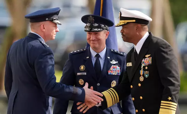 Gen. Dan Caine, center, chairman of the Joint Chiefs of Staff, looks on as Navy Adm. Alvin Holsey, right, shakes hands with Air Force Lt. Gen. Evan Pettus during a Holsey's relinquishment of command and retirement ceremony, at U.S. Southern Command, Friday, Dec. 12, 2025, in Doral, Fla. (AP Photo/Rebecca Blackwell)