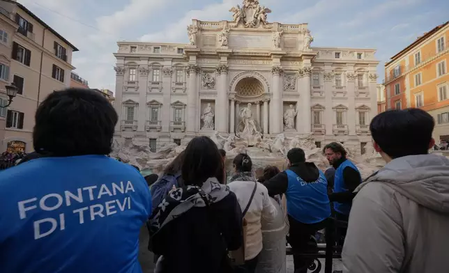 Staff controls the flow of visitors at Rome's Trevi Fountain, Friday, Dec. 19, 2025, as the city municipality announced that, starting on Feb. 1, it will impose a 2 euro fee for tourists to get close to the fountain. (AP Photo/Andrew Medichini)