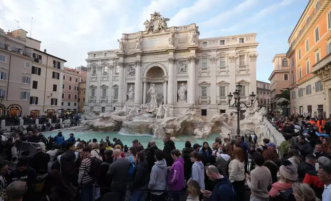Visitors admire Rome's Trevi Fountain, Friday, Dec. 19, 2025, as the city municipality announced that, starting on Feb. 1, it will impose a 2 euro fee for tourists to visit the recessed fountain edge. (AP Photo/Andrew Medichini)