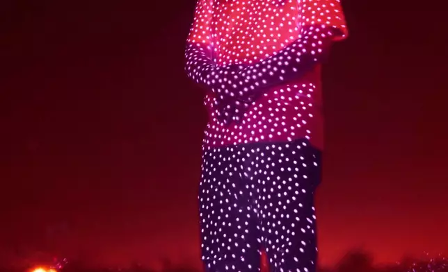 Retired Chinese official Li Chuanliang, who openly criticized the Chinese government after seeing first-hand how surveillance technology built up the government's power and is now being accused of corruption by Beijing, is illuminated by cellphone infrared facial recognition beams as he stands for a photo in the oil fields of Midland, Texas, where he's currently living in exile, Oct. 11, 2025. (AP Photo/David Goldman)
