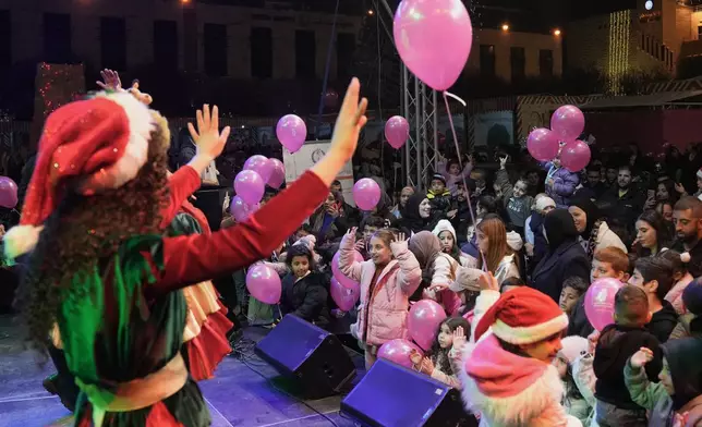 Palestinians watch performances in Manger Square in the West Bank city of Bethlehem, Friday, Dec. 12, 2025. (AP Photo/Mahmoud Illean)