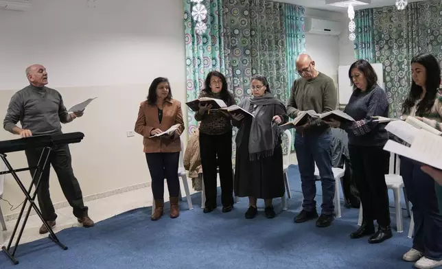 Joseph Hazboun, left, leads the rehearsal of a choir in St. Catherine's Church in the West Bank city of Bethlehem, Friday, Dec. 12, 2025. (AP Photo/Mahmoud Illean)