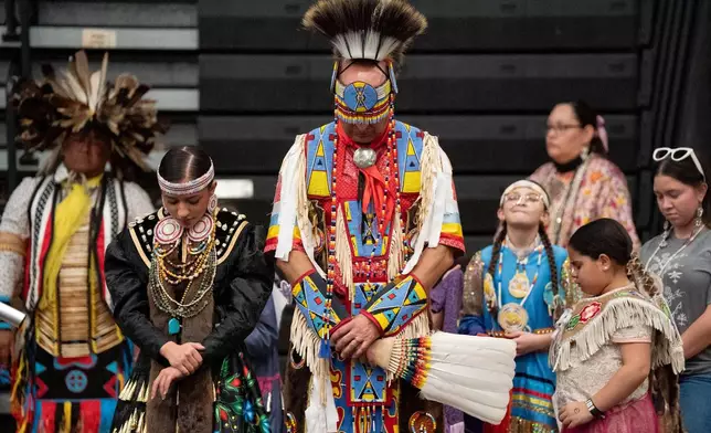 FILE - Members of the Lumbee Tribe bow their heads in prayer during the BraveNation Powwow and Gather at UNC Pembroke, March 22, 2025, in Pembroke, N.C. (AP Photo/Allison Joyce, file)