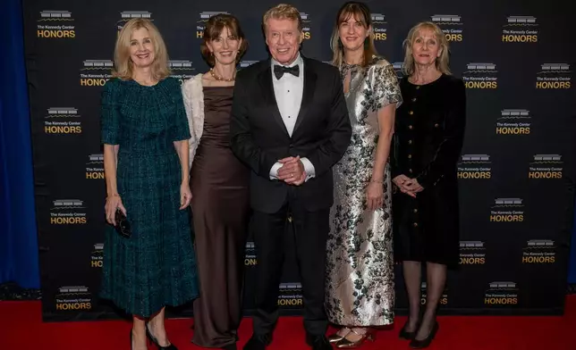 2025 Kennedy Center Honoree Michael Crawford, center, and his family arrive on the red carpet for the 48th Kennedy Center Honors Medallion Reception, hosted at the U.S. Department of State, Saturday, Dec. 6, 2025 in Washington. (AP Photo/Kevin Wolf)