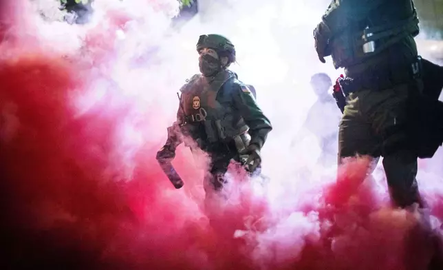 FILE - Police and federal officers deploy gas canisters to disperse protesters near a U.S. Immigration and Customs Enforcement facility in Portland, Ore. on Oct. 5, 2025. (AP Photo/Ethan Swope, File)