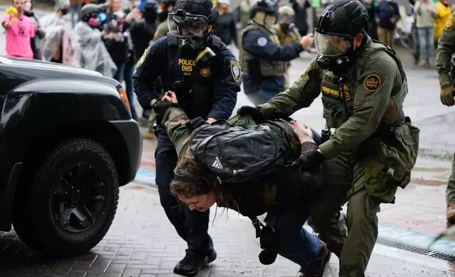 FILE - A protester is detained outside the U.S. Immigration and Customs Enforcement facility on Sunday, Oct. 12, 2025, in Portland, Ore. (AP Photo/Jenny Kane, File)