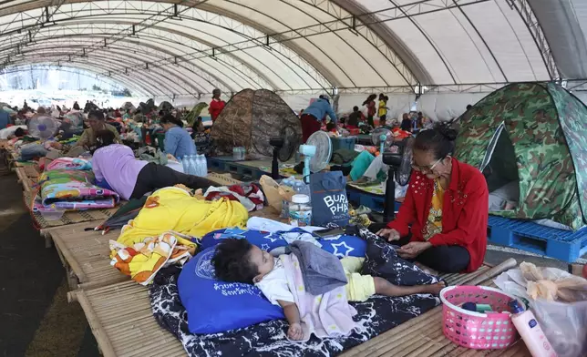 Thai residents who fled homes as Thailand and Cambodia clash over border, rest at an evacuation center in Buriram province, Thailand, Monday, Dec. 8, 2025. (AP Photo/Sopa Saelee)