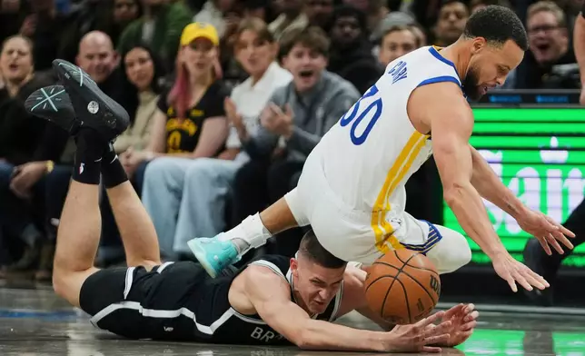 Brooklyn Nets' Egor Demin (8) fights for control of the ball with Golden State Warriors' Stephen Curry (30) during the first half of an NBA basketball game Monday, Dec. 29, 2025, in New York. (AP Photo/Frank Franklin II)