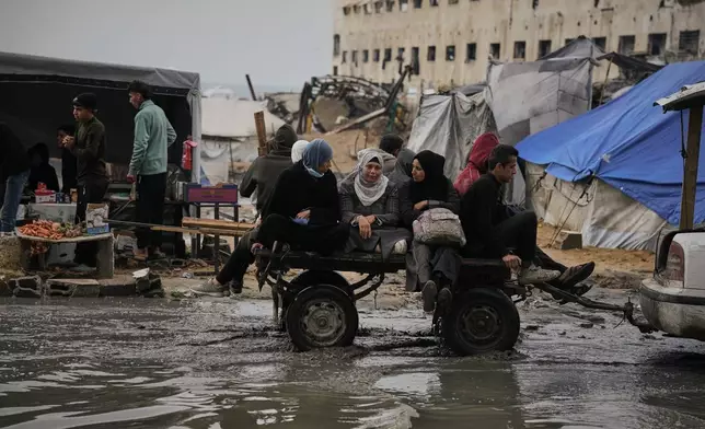 Palestinians ride in a cart pulled by a vehicle through a flooded street after stormy weather in Gaza City Wednesday, Dec. 10, 2025. (AP Photo/Jehad Alshrafi)