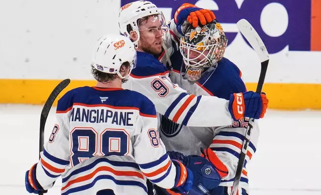 Edmonton Oilers goaltender Tristan Jarry, right, celebrates with Connor McDavid, center, and Andrew Mangiapane (88) following an NHL hockey game against the Pittsburgh Penguins in Pittsburgh, Tuesday, Dec. 16, 2025. (AP Photo/Gene J. Puskar)