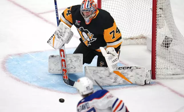 Edmonton Oilers' Connor McDavid (97) has a shot blocked by Pittsburgh Penguins goalie Stuart Skinner (74) during the first period of an NHL hockey game in Pittsburgh, Tuesday, Dec. 16, 2025. (AP Photo/Gene J. Puskar)