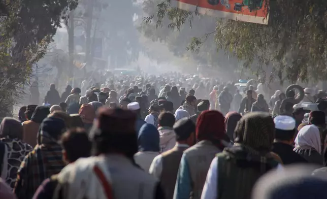A crowd heads toward a stadium to attend the public execution, carried out by Taliban authorities, of a man sentenced by the Supreme Court for killing 13 members of a family, including children, earlier this year, in the eastern city of Khost, Afghanistan, Tuesday, Dec. 2, 2025. (AP Photo/Saifullah Zahir)