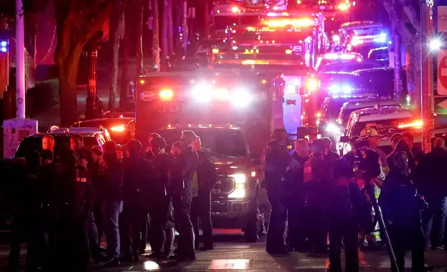 Emergency personnel gather on Waterman Street at Brown University in Providence, R.I., on Saturday, Dec. 13, 2025, during the investigation of a shooting. (AP Photo/Mark Stockwell)