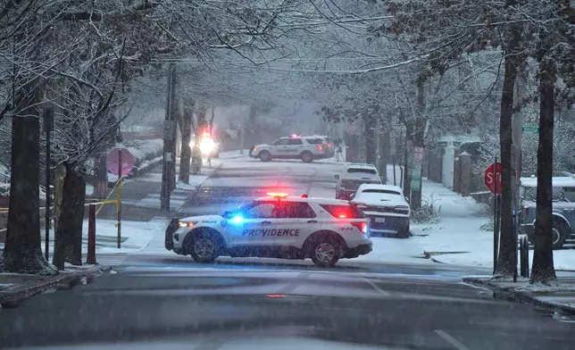 Police vehicles rest in intersections in a neighborhood near Brown University, Sunday, Dec. 14, 2025, in Providence, R.I., following a shooting at the university Saturday, Dec. 13. (AP Photo/Steven Senne)