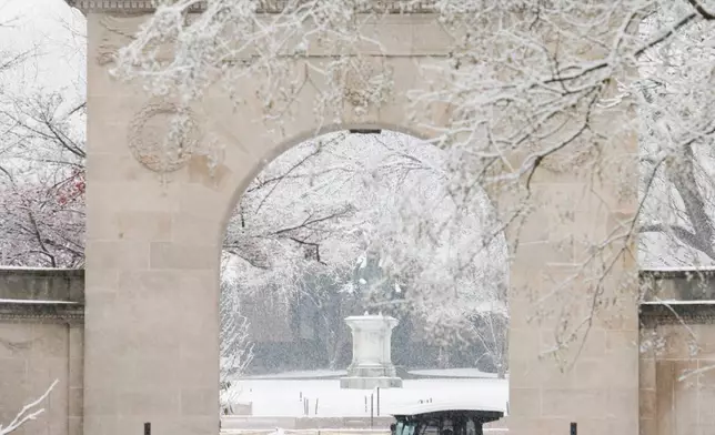 Pedestrians walk past and glance at the scene of a shooting at Brown University Sunday, Dec. 14, 2025, after a shooting on Saturday in Providence, R.I. (Lily Speredelozzi/The Sun Chronicle via AP)