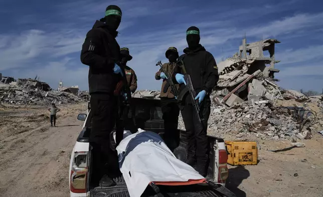 Islamic Jihad and Hamas militants carry a white body bag that is believed to be the remains of a deceased hostage, in the town of Beit Lahiya in northern Gaza Strip, Wednesday, Dec. 3, 2025. (AP Photo/Jehad Alshrafi).