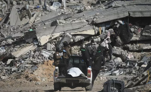 Islamic Jihad and Hamas militants carry a white body bag that is believed to be the remains of a deceased hostage, in the town of Beit Lahiya in northern Gaza Strip, Wednesday, Dec. 3, 2025. (AP Photo/Jehad Alshrafi).