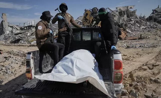 Islamic Jihad and Hamas militants carry a white body bag that is believed to be the remains of a deceased hostage, in the town of Beit Lahiya in northern Gaza Strip, Wednesday, Dec. 3, 2025. (AP Photo/Jehad Alshrafi).