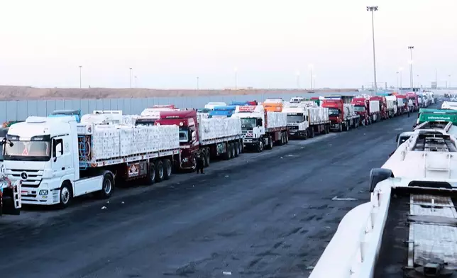 FILE -Trucks carrying humanitarian aids prepare to cross the Egyptian gate of the Rafah crossing, waiting for inspections by Israeli authorities before entering the Gaza Strip, following an agreement between Israel and Hamas on a ceasefire, Oct. 20, 2025. (AP Photo/Mohamed Arafat, File)