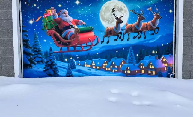 A Christmas mural overlooks fresh snow in Lowville, N.Y., on Saturday, Dec. 27, 2025. (AP Photo/Cara Anna)